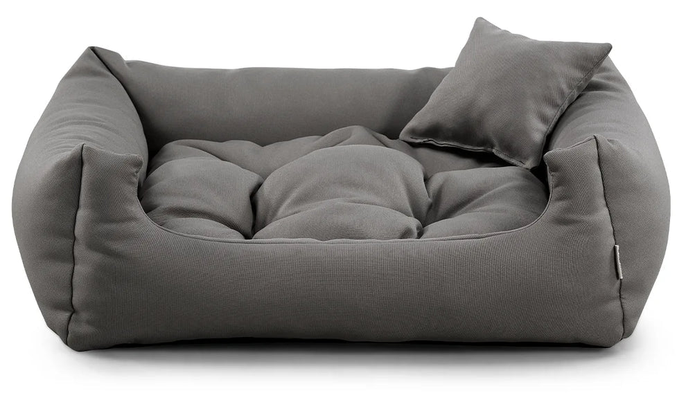 Ash grey corduroy dog bed with raised edges and cushion.