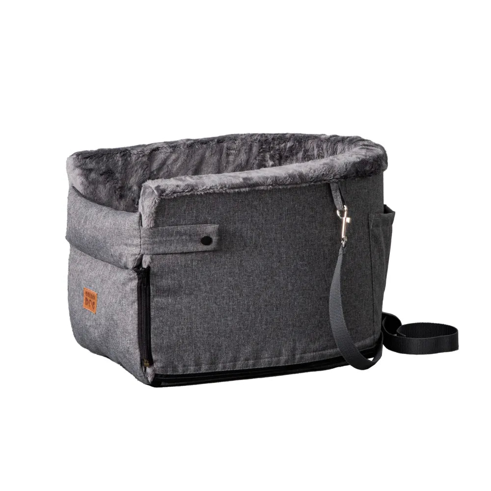 Grey dog car seat securely mounted between the front seats of a car with tan leather upholstery; features padded sides, side zip and a branded Golden Dog patch — designed for small pets to travel safely and stylishly
