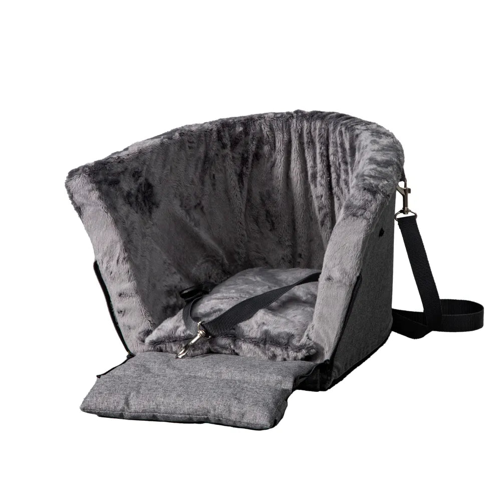 Grey dog car seat securely mounted between the front seats of a car with tan leather upholstery; features padded sides, side zip and a branded Golden Dog patch — designed for small pets to travel safely and stylishly