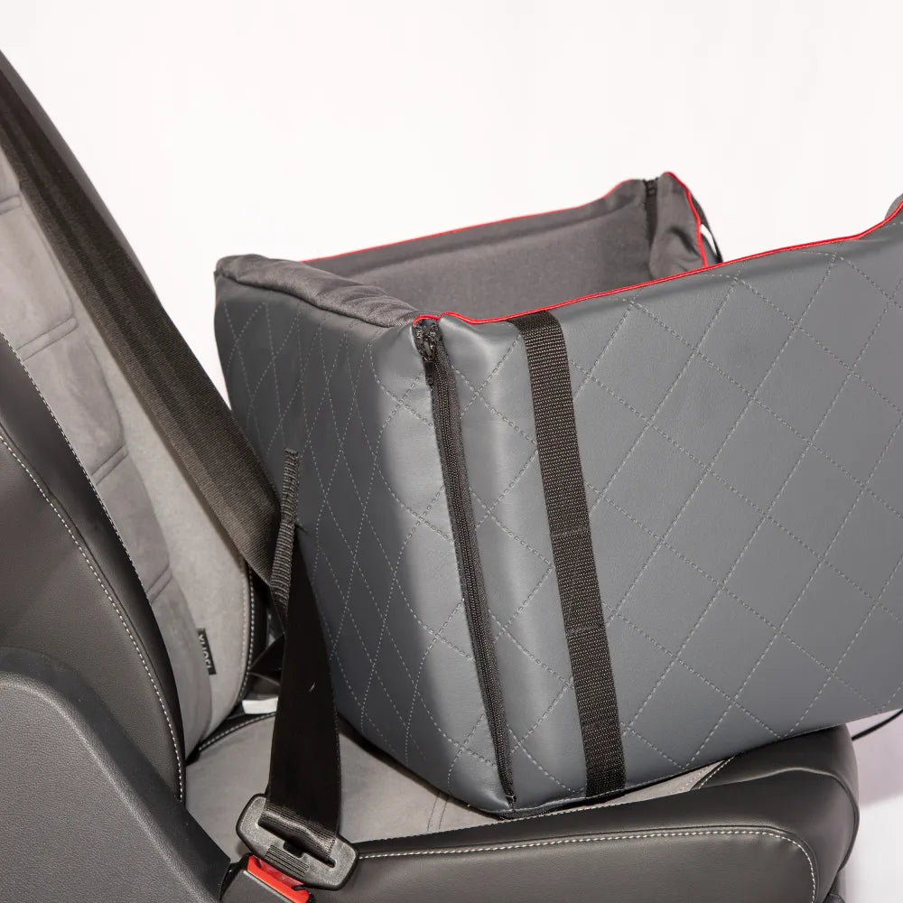Stylish grey quilted dog car seat with red piping, Golden Dog logo patch and embroidered paw print — securely fastened for comfortable car travel