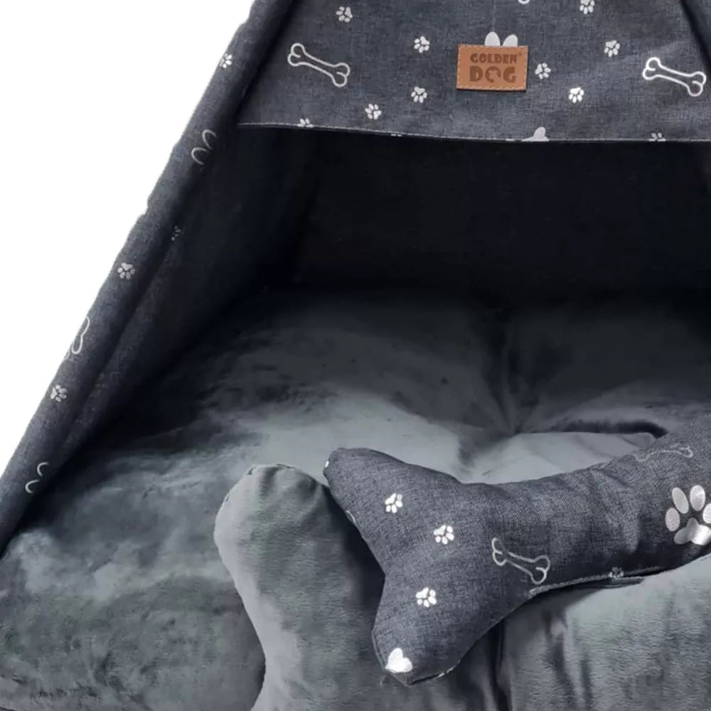 Tipi-style dog bed made from dark grey fabric with silver paw print pattern — includes matching cushion and bone-shaped pillow, supported by wooden poles