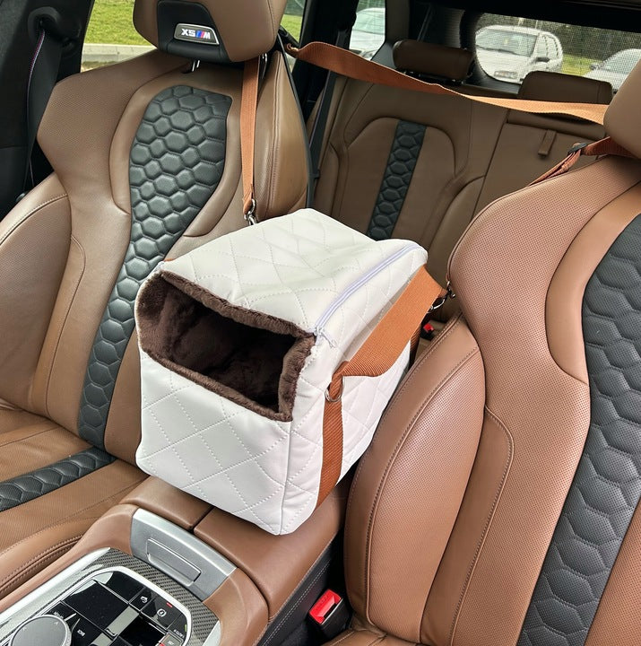 White quilted dog travel bag with brown shoulder straps and soft plush interior; — a stylish and secure pet carrier for small breeds.