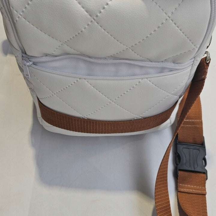 White quilted dog travel bag with brown shoulder straps and soft plush interior; — a stylish and secure pet carrier for small breeds.