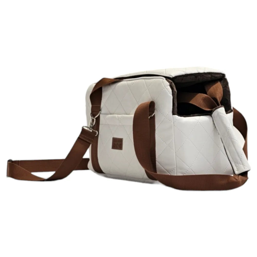 White quilted dog travel bag with brown shoulder straps and soft plush interior; — a stylish and secure pet carrier for small breeds.