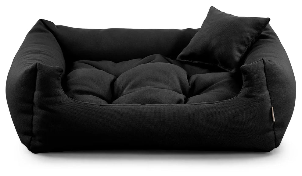 Black corduroy dog bed with raised edges and cushion.