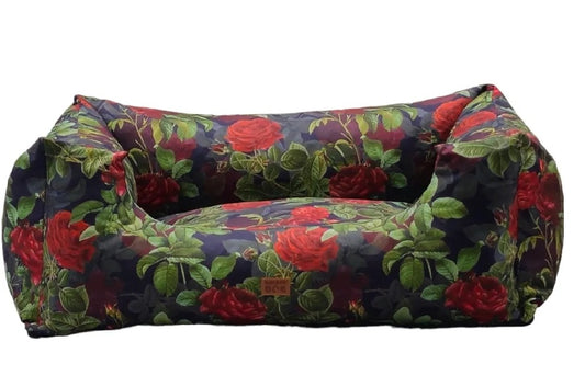 Sofa-style dog bed with floral rose pattern — red roses and green leaves on a dark background, featuring raised sides for comfort and decorative elegance