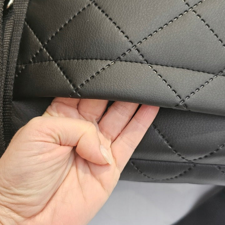 Graphite quilted dog travel bag with brown shoulder straps and soft plush interior — a stylish and secure pet carrier for small breeds.