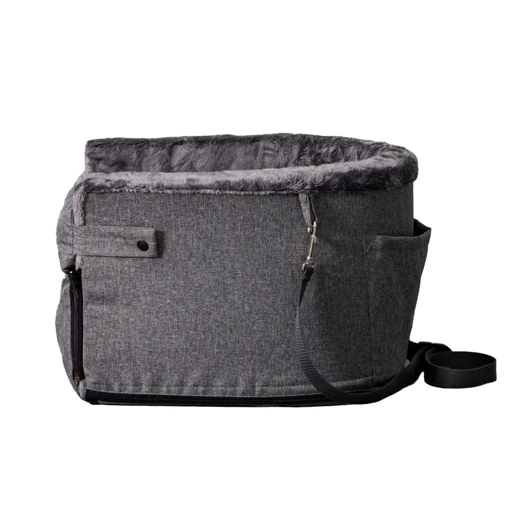 Grey dog car seat securely mounted between the front seats of a car with tan leather upholstery; features padded sides, side zip and a branded Golden Dog patch — designed for small pets to travel safely and stylishly