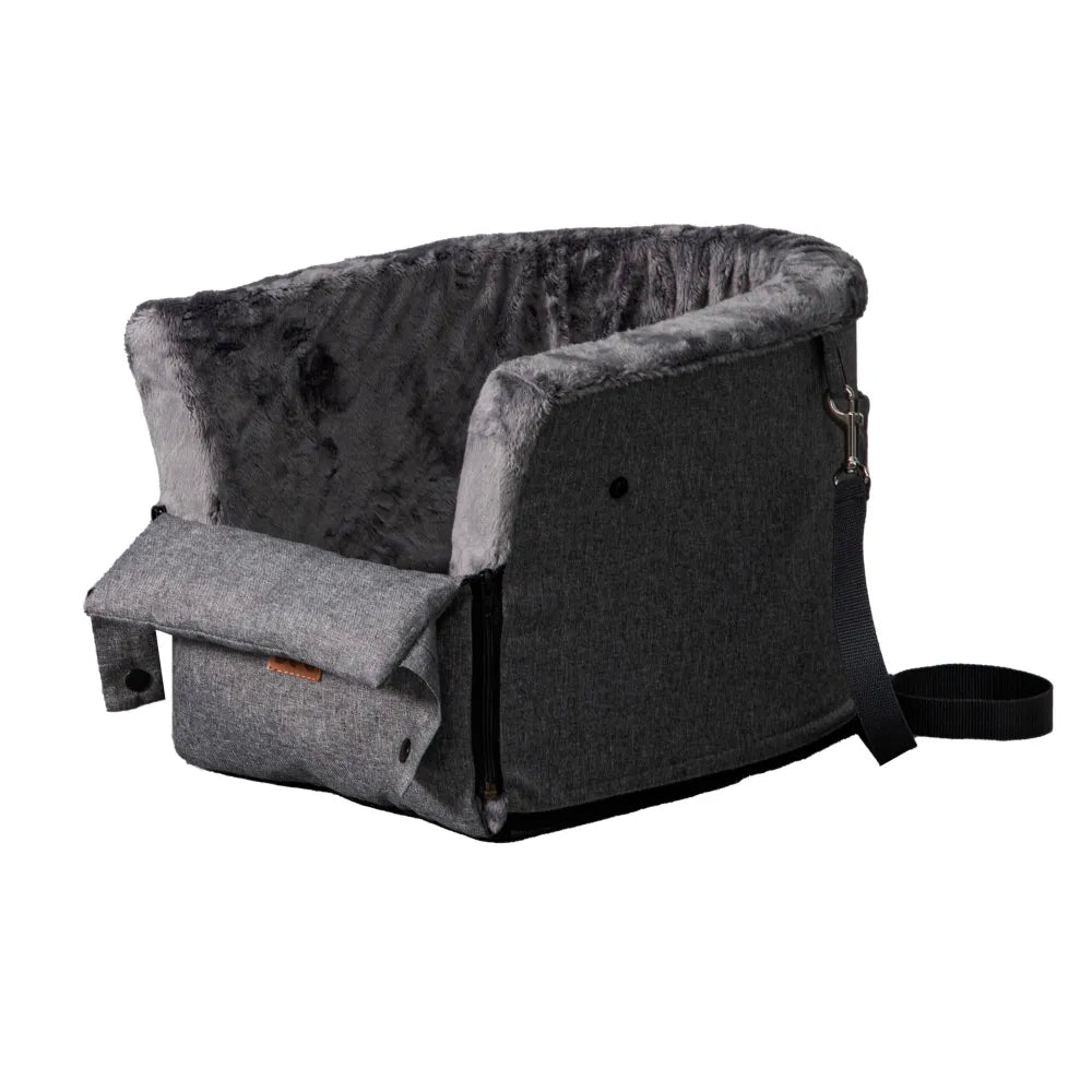 Grey dog car seat securely mounted between the front seats of a car with tan leather upholstery; features padded sides, side zip and a branded Golden Dog patch — designed for small pets to travel safely and stylishly