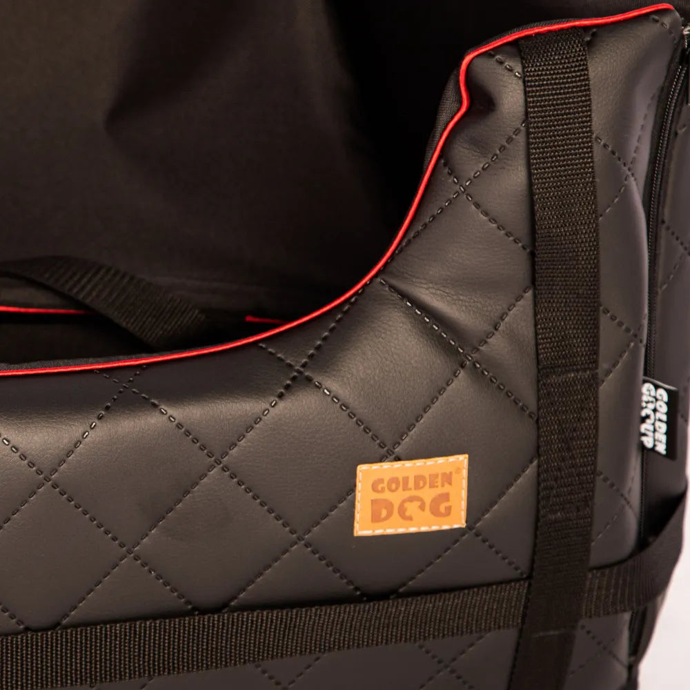 Stylish black quilted dog car seat with red piping, Golden Dog logo patch and embroidered paw print — securely fastened for comfortable car travel
