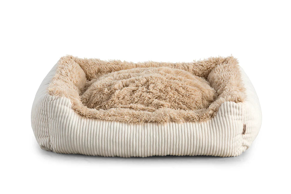 Shaggy dog bed in beige colour fabric with small pillow.