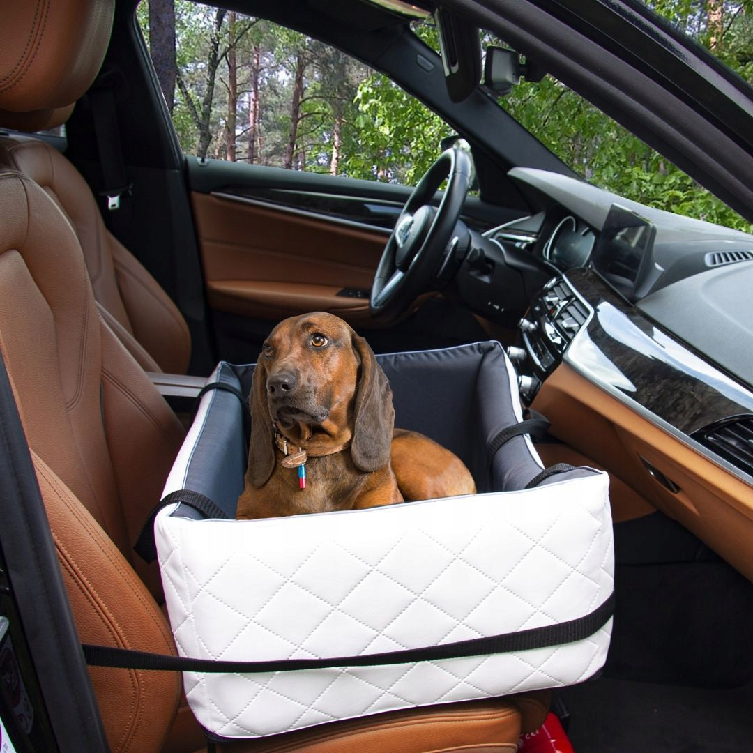 White quilted dog car seat cover ; includes adjustable securing straps and fits standard car seats — a protective travel accessory for pet owners.